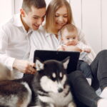 Família sorridente escolhendo o melhor plano de saúde pet, com um cachorro fofo ao lado, ilustrando os benefícios e a tranquilidade de proteger a saúde do pet.